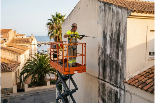 Limpieza de fachada con hidrolimpiadora desde plataforma elevadora